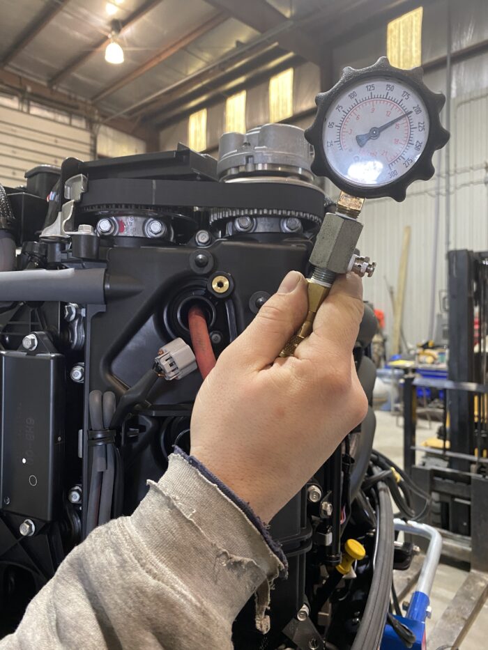 Mechanic measuring pressure on engine gauge.