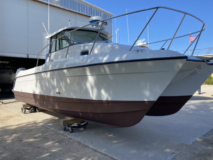 Two-hulled boat in boatyard setting.